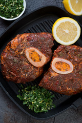 Top view of raw marinated cross cut veal shank with gremolata and lemon, close-up, vertical shot