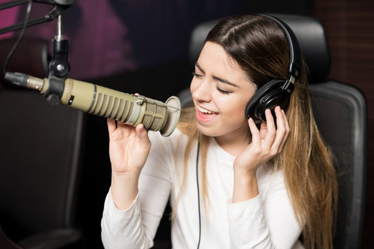 Female singer performing live song at radio station
