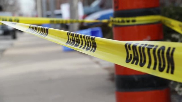 Construction site with yellow caution tape and orange pilons blocking off the area.