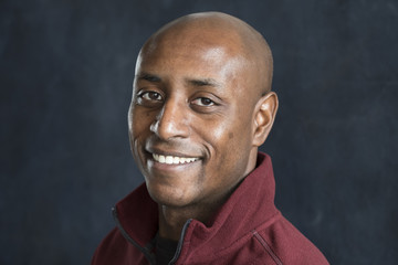 Portrait of a black man with a shaved head smiling