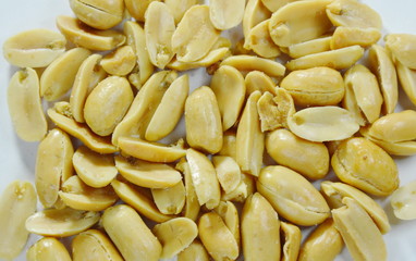 baked salt peanuts on white background