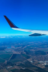Fototapeta premium View from the airplane window on the wing and clouds in the sky.