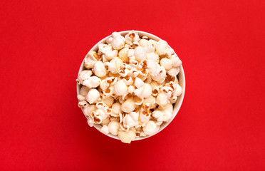 Popcorn viewed from above on a red background. Flat lay of pop corn bowl. Top view