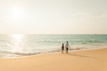 Older brother and sister relaxing on the sunset beach.