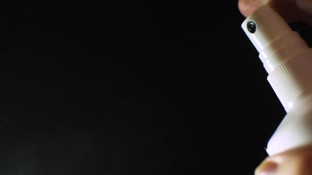Conception: atomizer in slow motion on black background for ideas in advertising, medicine and education