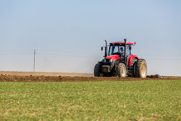 Tractor cultivating field at spring