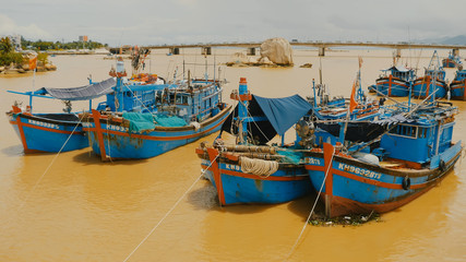 Fototapeta na wymiar Vietnam. Fishing boats with red flags in Nha Trang,
