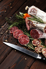 thinly sliced salami on a wooden texture on the background.