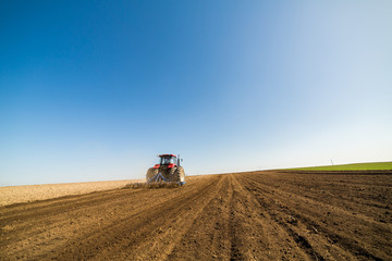 Tractor cultivating field at spring