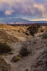 A path leading to a sunset storm over distant mountains