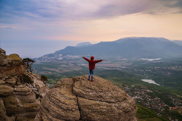 Obraz premium Young woman standing on top of cliff