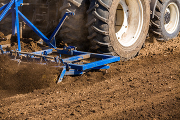 Tractor cultivating field at spring