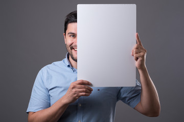 Youn man holds board