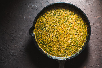 Yellow curry paste on a cast-iron frying pan. Indian food