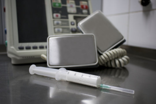 cardiac defibrillator and the syringe of propofol on the medical table