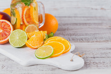Citrus fruit and herbs water for detox or dieting in glass bottles. Limes and oranges