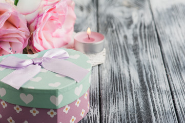 Pink gift box, roses, lit candle