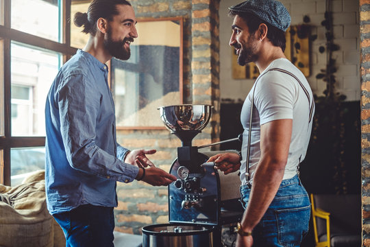 Male owners standing happy by the coffee roaster