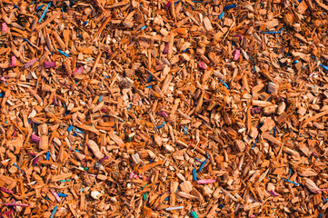 Textured background decorative colored sawdust for finishing flowerbeds in the winter season. Yellow orange sawdust