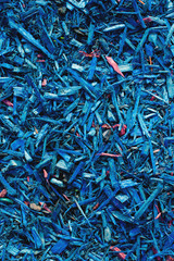 Textured background decorative colored sawdust for finishing flowerbeds in the winter season. Blue sawdust