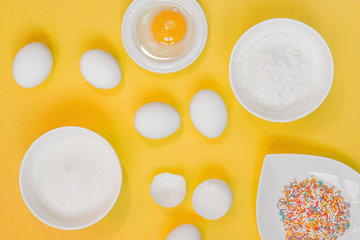 concept of the Easter bakery, various products for home baking, sugar, eggs and flour, coconut munt, top view, empty space for text on a yellow background in the style of pop art mocap layout