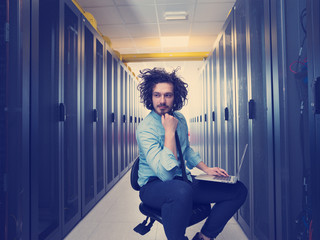 engineer working on a laptop in server room