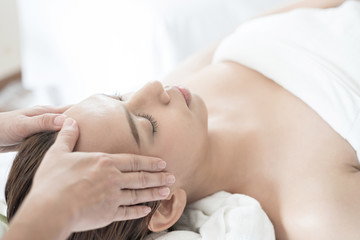 beautiful and healthy young woman relaxing with face massage  at beauty spa salon