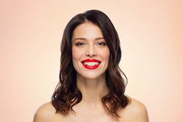 beauty, make up and people concept - happy smiling young woman with red lipstick over beige background