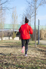 Active and sporty woman runner in autumn nature
