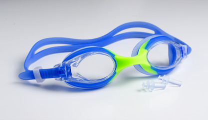 Blue glasses for swim on white background, ear plugs.