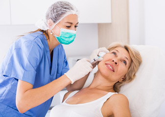 Woman during beauty facial injections