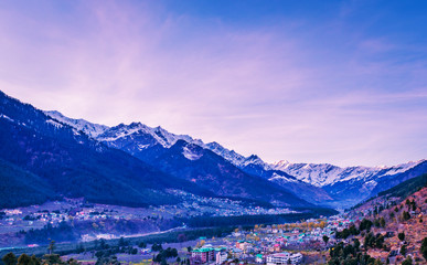 View of Manali City and snow covered Himalayas mountains in India from the top of a mountain 