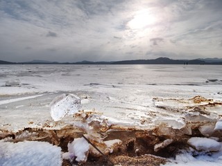 Transparent ice block on  frozen sea surface. Amazing Sun  reflection