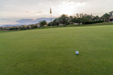 Obraz premium Golf ball on green fairway blue cloudy summer sky in the background