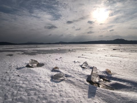 Melting ice crystals and icebergs. The beach covered by thick ice