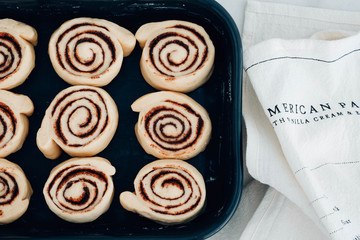 Cinnamon rolls or cinnabon handmade raw dough preparation with spices. Sweet Homemade Pastry christmas baking. Kanelbule - swedish dessert. Top view.