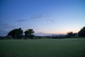 Golf green fairway and blue cloudy summer sky at sunset  in the background