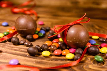 Foto op Plexiglas Chocolate easter eggs and multicolored candies on wooden table © ihorbondarenko