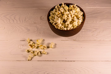 Ceramic bowl with popcorn on wooden table