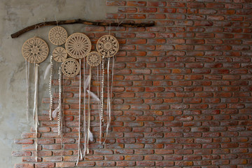  dream catchers made with their hands weigh on a brick brown wall