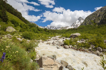 Movement of clouds and water flows in a stormy river in the Caucasus mountains in summer