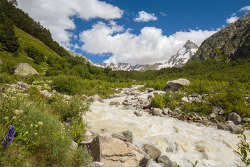 Movement of clouds and water flows in a stormy river in the Caucasus mountains in summer