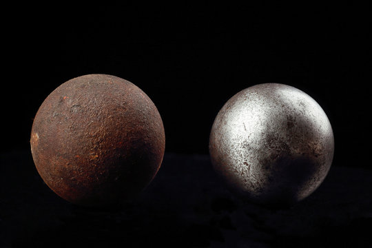 Two metal balls on a black background.