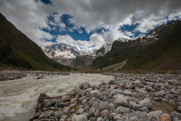 Fototapeta na wymiar Movement of clouds and water flows in a stormy river in the Caucasus mountains in summer