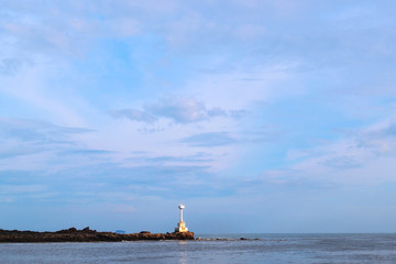 Fototapeta premium Seascape with a lighthouse on the horizon. Beautiful blue sky.