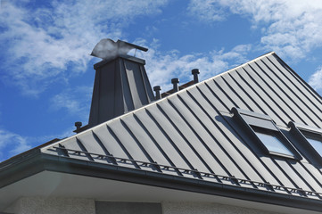 Modernes Stehfalz-Metalldach mit Dachfenster, Schneefang, Dachrinne, Dunstabzügen und mit Metall verkleidetem Schornstein - obrazy, fototapety, plakaty