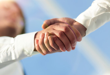 Close-up photo of handshake of two successful businessmen