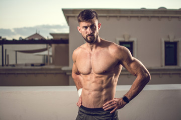 Sexy athletic muscular man with six-pack abs outdoors