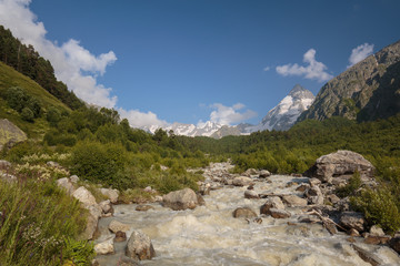 Movement of clouds and water flows in a stormy river in the Caucasus mountains in summer