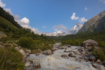 Movement of clouds and water flows in a stormy river in the Caucasus mountains in summer